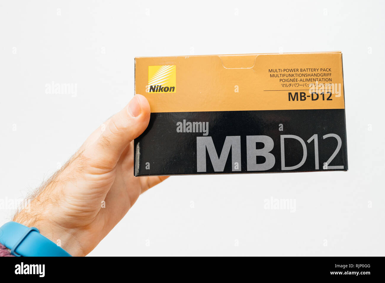 PARIS, FRANCE - FEB 5, 2018: Photographer hand holding against white background a box with Nikon MB-D12 camera grip for the Nikon D810 D800 professional DSLR camera front view Stock Photo