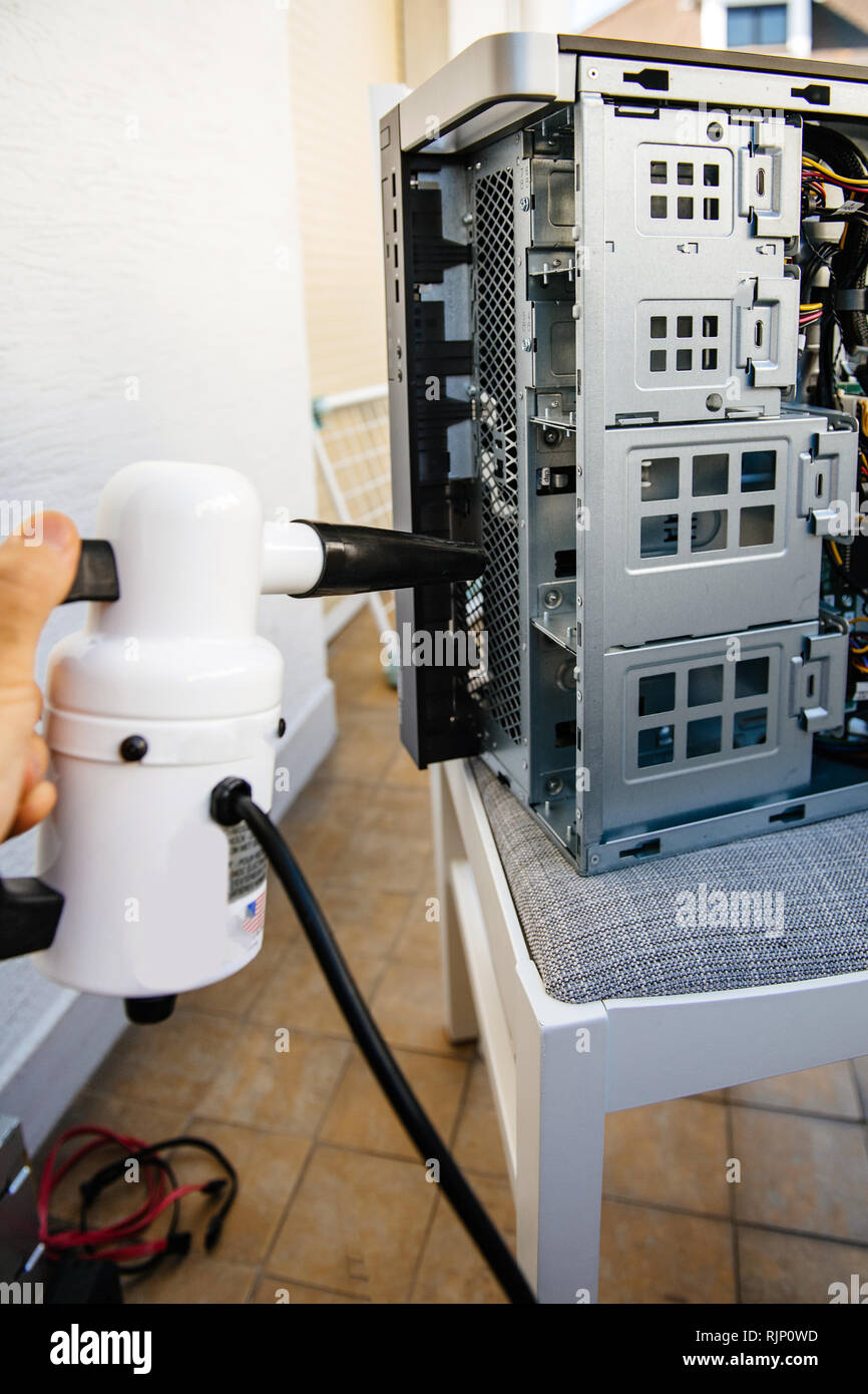 Side view of man hand holding vacuum pump to clean computer case on