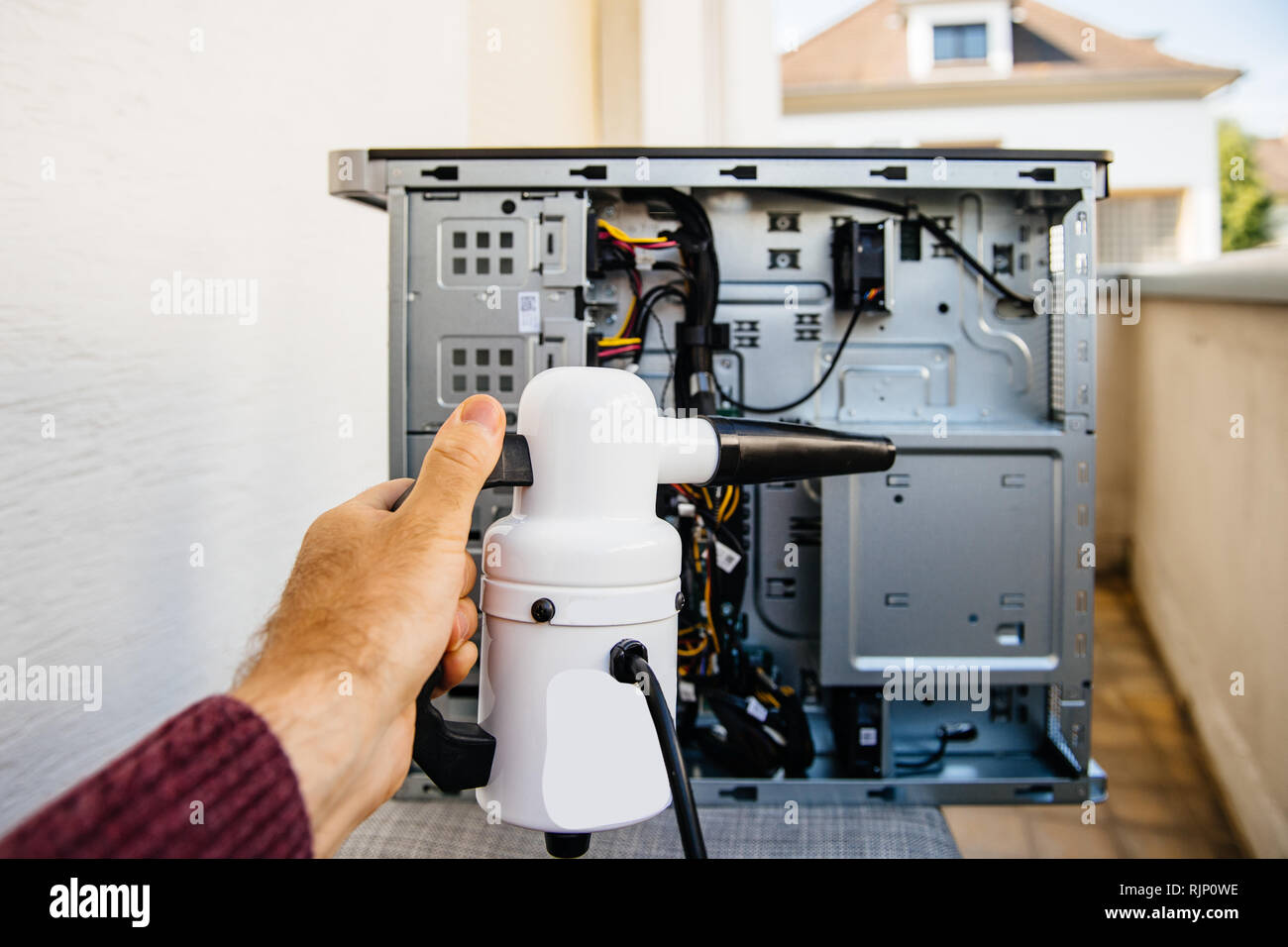 Cleaning with vacuum pump to clean computer case on balcony from the