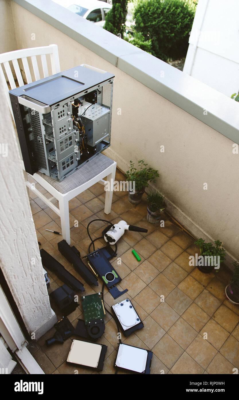 Clean computer case on balcony with multiple HDD and GPU on floor