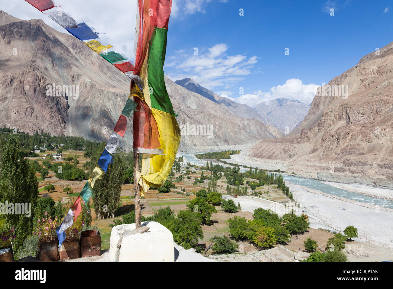 Prayer flags near Buddhist Gompa and scenery of Turtuk village and Shyok River (view towards K2 in Pakistan), Nubra Valley, Ladakh, India Stock Photo