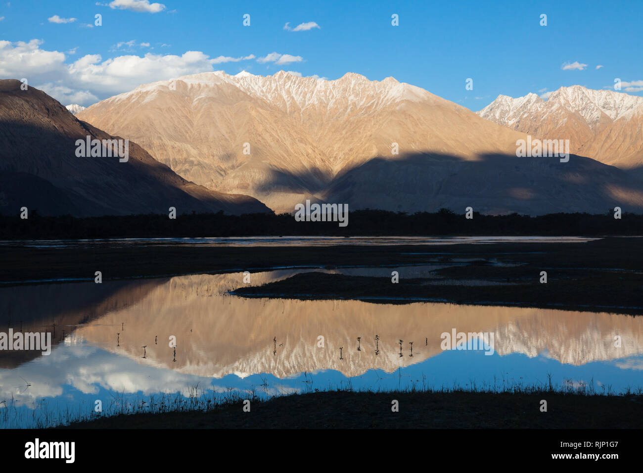 Beautiful landscape with slightly snow-capped mountains reflecting in the water, area of Hunder, Nubra Valley, Ladakh, Jammu and Kashmir, India Stock Photo