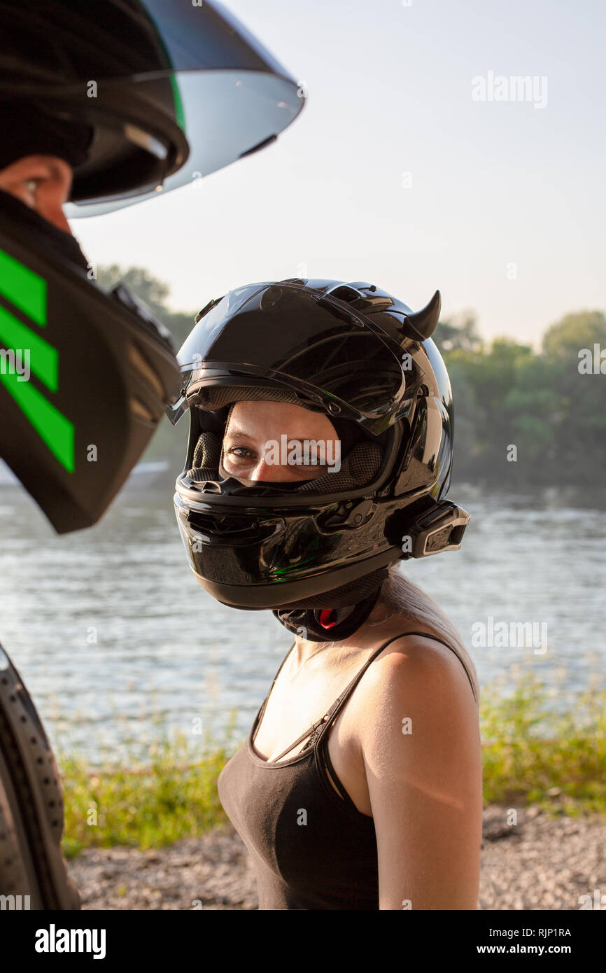 Portrait of bikers man and woman in helmets look at each other