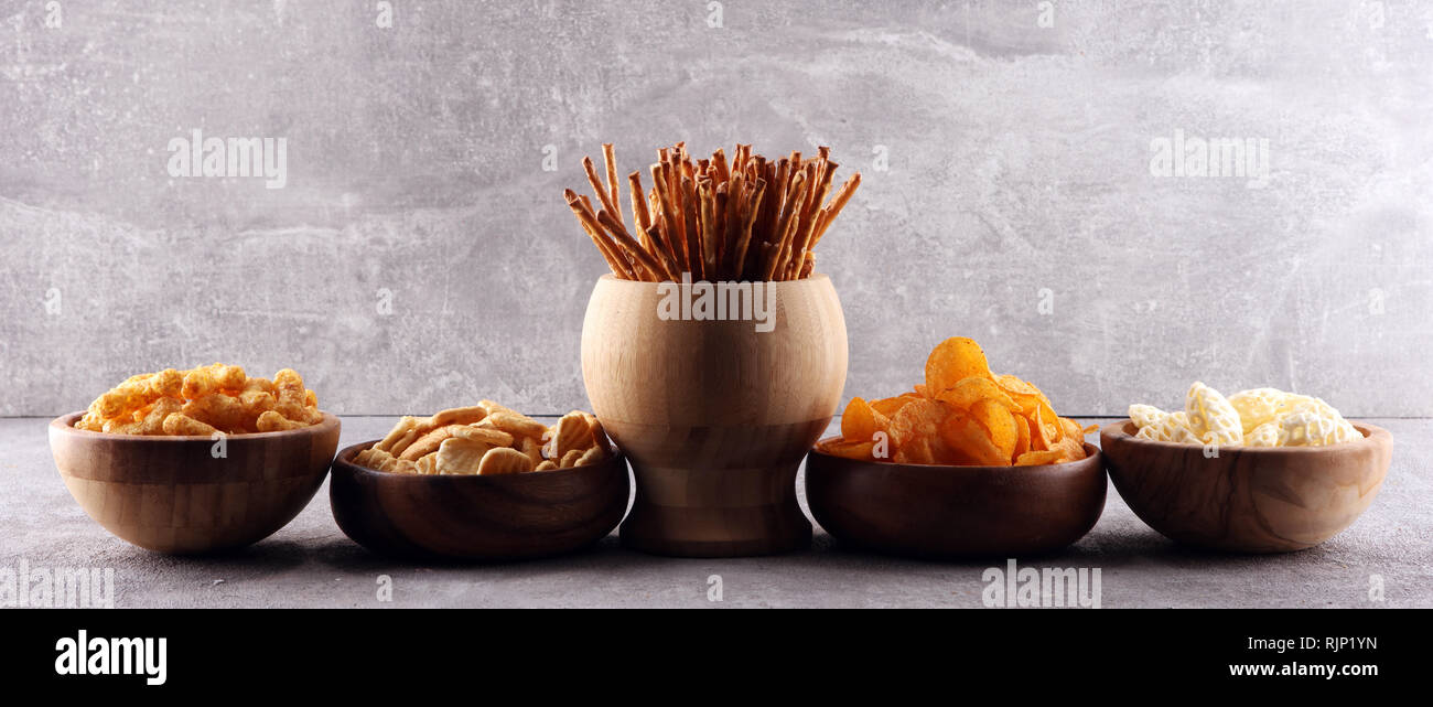 Salty snacks. Pretzels, chips, crackers in wooden bowls. Unhealthy