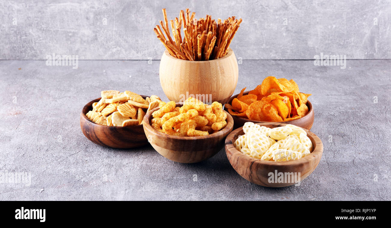 Salty snacks. Pretzels, chips, crackers in wooden bowls. Unhealthy
