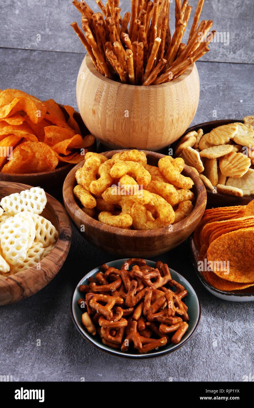 Salty snacks. Pretzels, chips, crackers in wooden bowls. Unhealthy