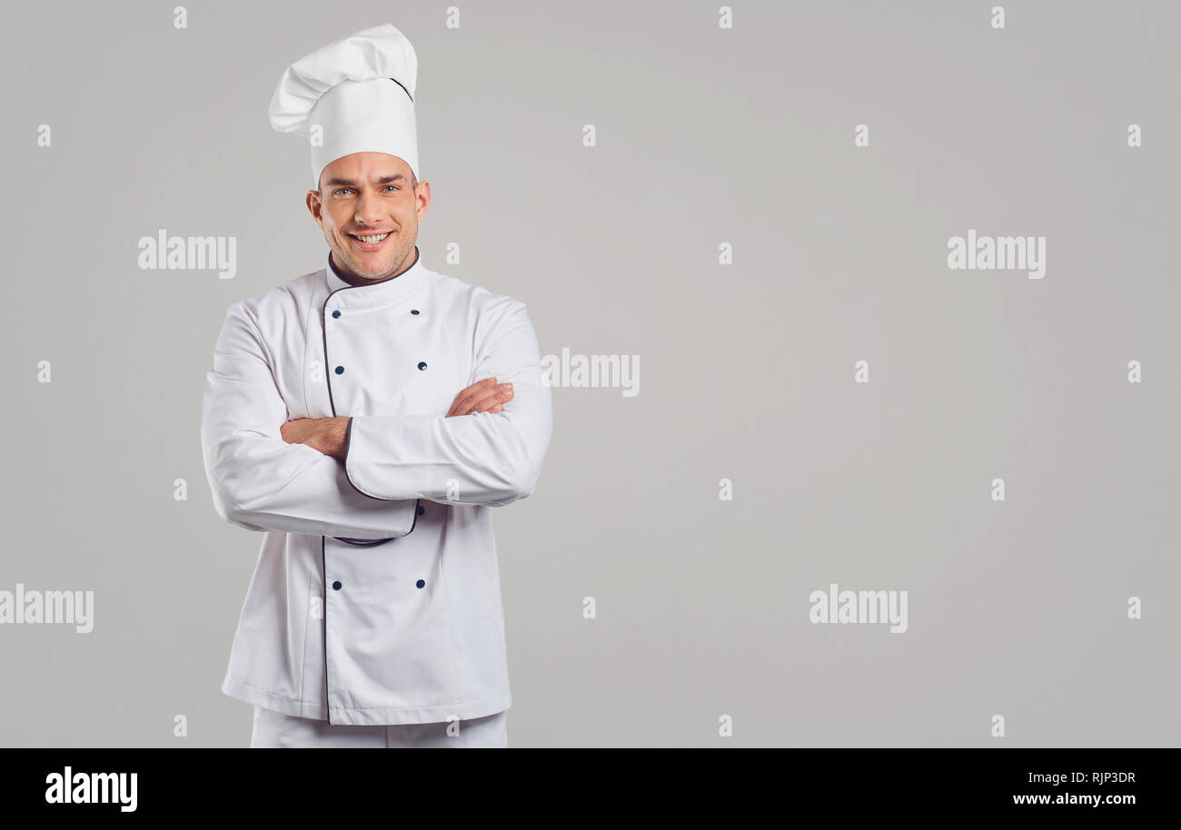 Cook in white uniform is smiling. Stock Photo