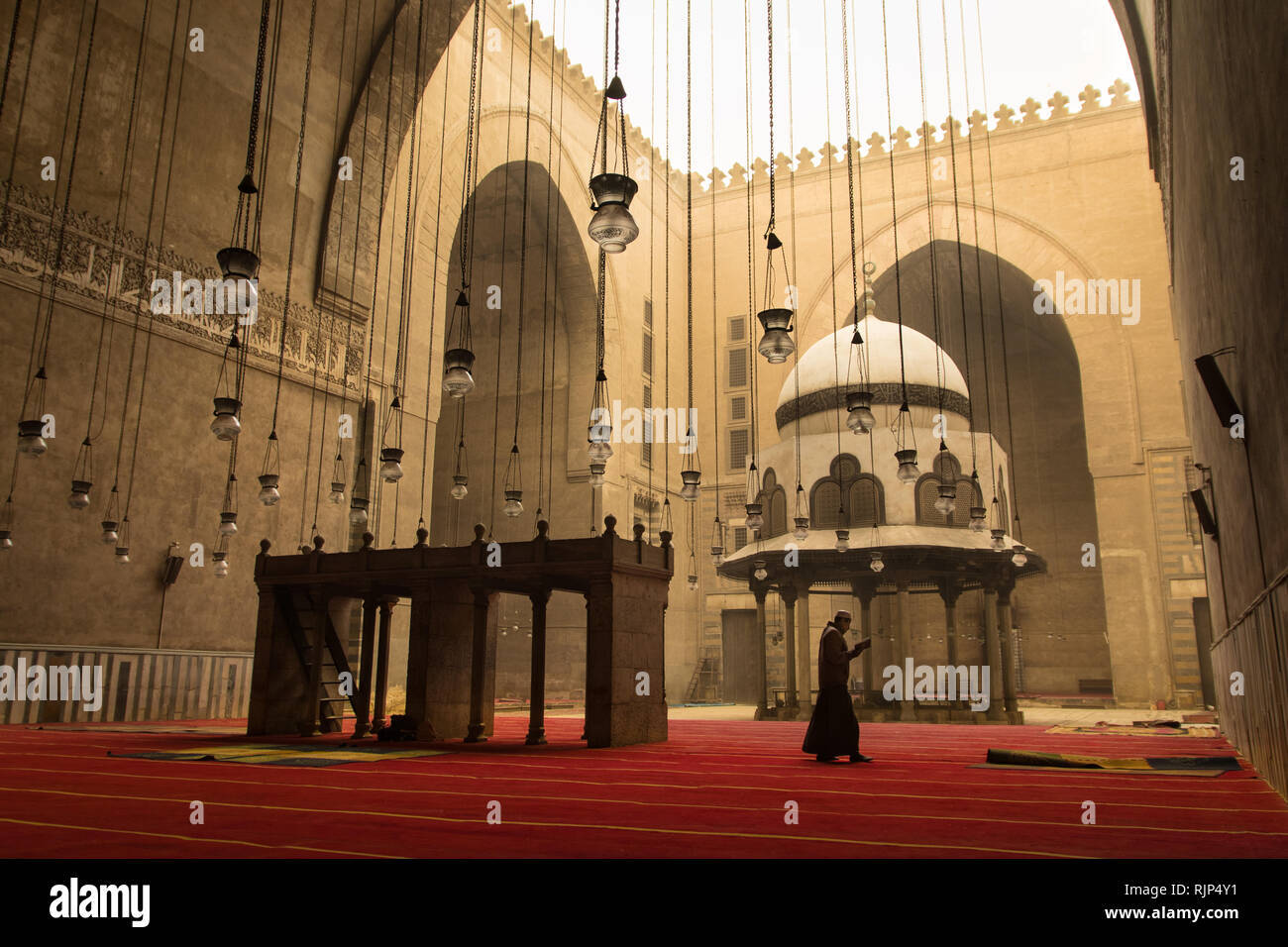 A prayer reads the Quran at the Mosque-Madrassa of Sultan Hassan in Cairo city, Egypt. Stock Photo