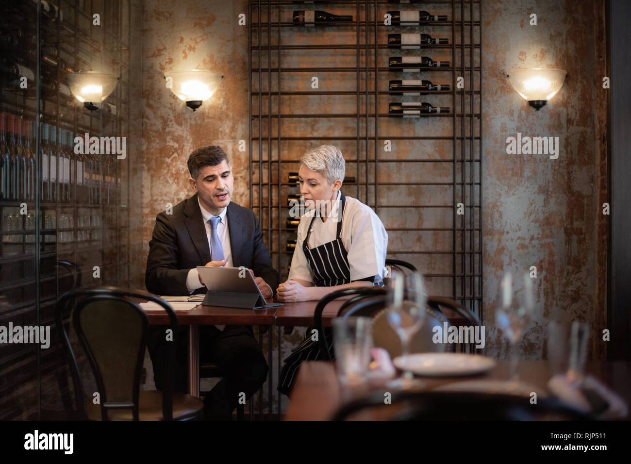 Chef and restaurant owner talking with financial advisor investor Stock Photo