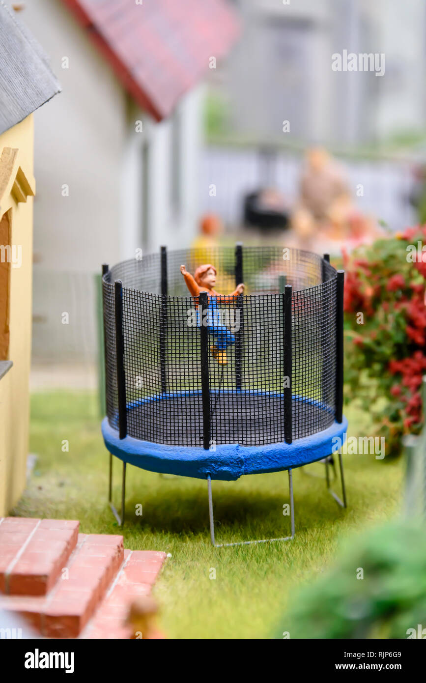 Miniature model of a child on a trampoline in his garden, at Kolejkowo, Wrocław, Wroclaw, Wroklaw, Poland Stock Photo