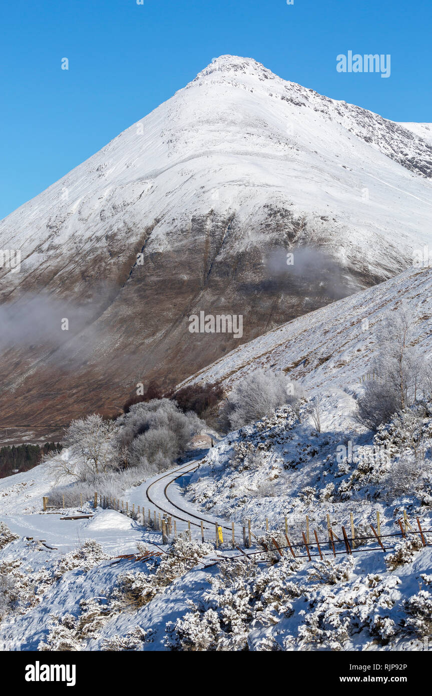 Snow covered Beinn Dorian and the single track West Highland Railway line near Auch, Argyll and Bute, Scotland Stock Photo
