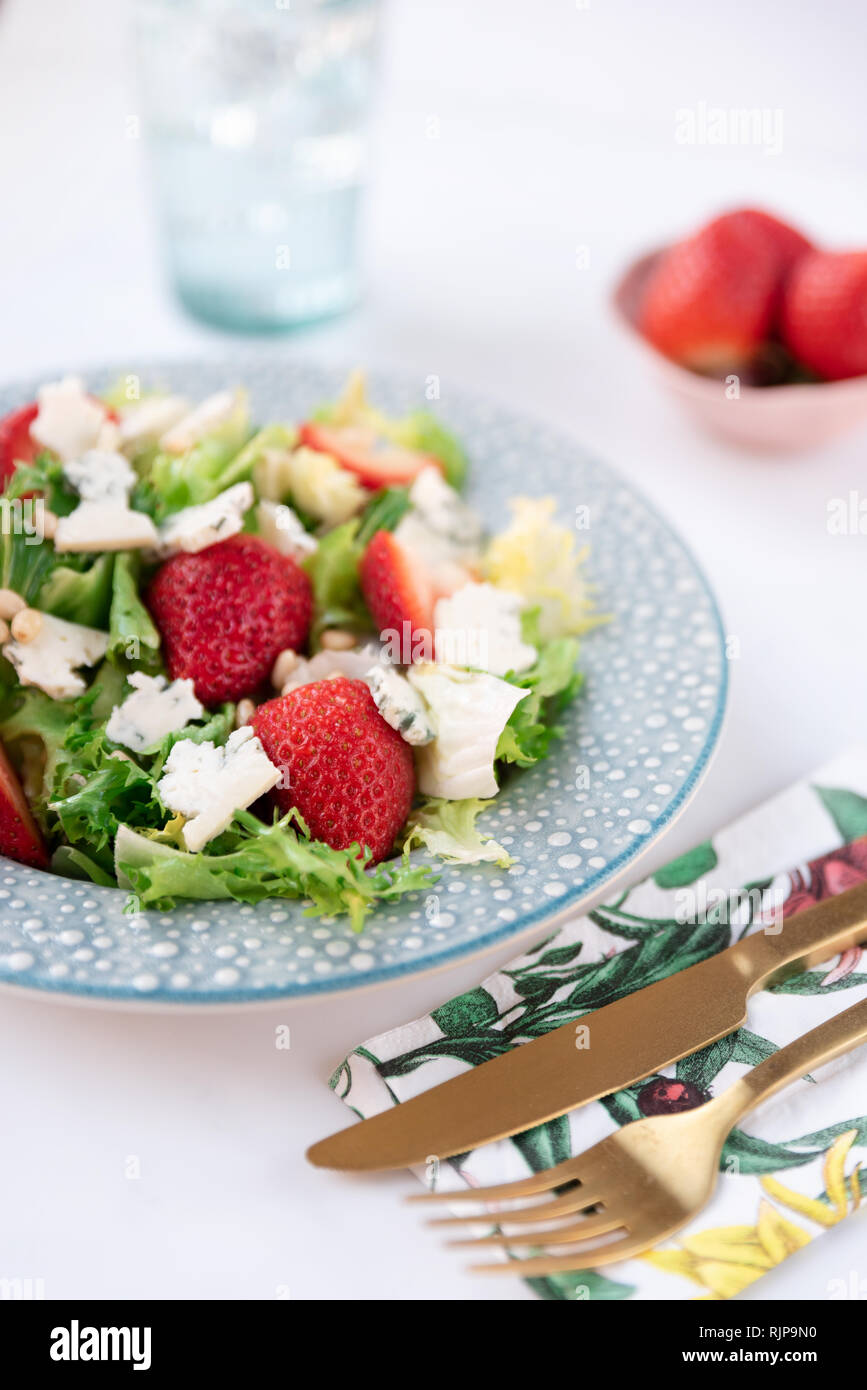 Salat with cheese and strawberries on plate. Healthy food, diet and nutrition concept Stock Photo