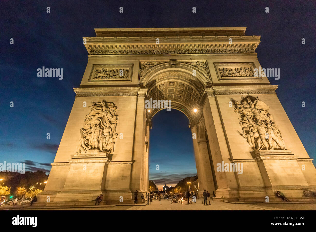 Arc de Triomphe de l'Étoile at night.The Arch sits in a circular plaza from which 12 grand avenues radiate, forming a star (étoile) ,Paris Stock Photo