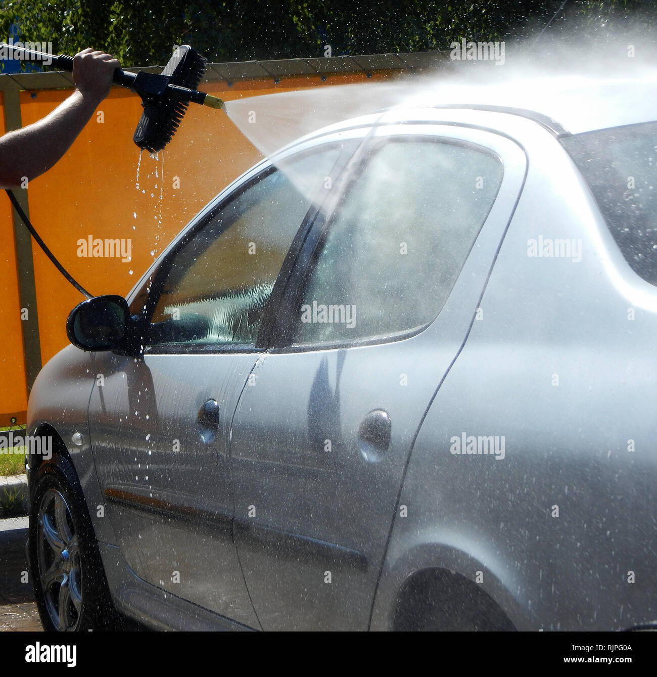 Water spray from high pressure jet washer cleaning car windows Stock Photo
