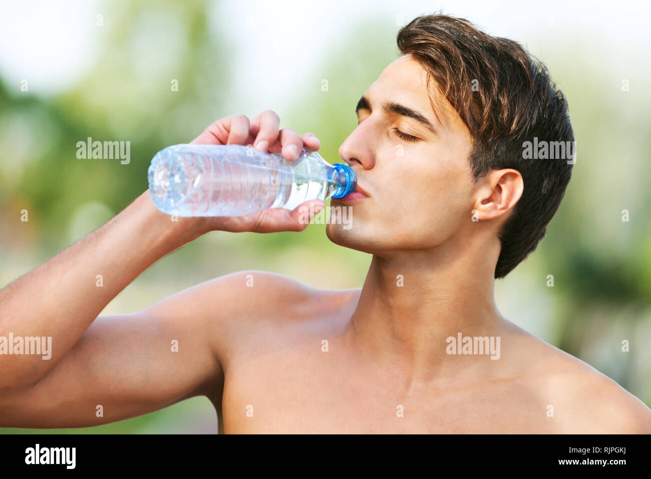 Young man drinking water after jogging Stock Photo