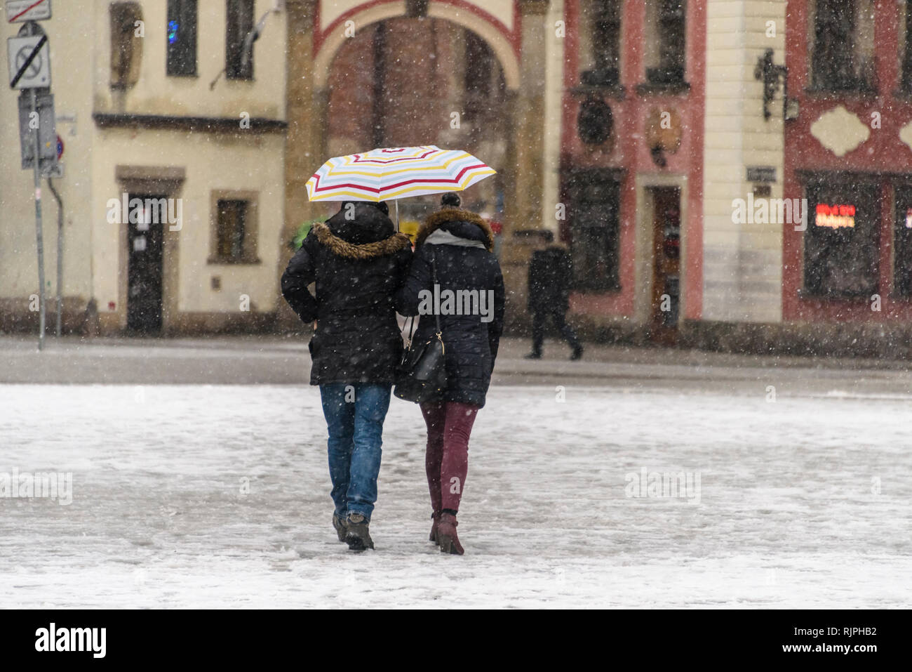 A couple walks in snow carrying an umbrella, Wrocław, Wroclaw, Wroklaw, Poland Stock Photo