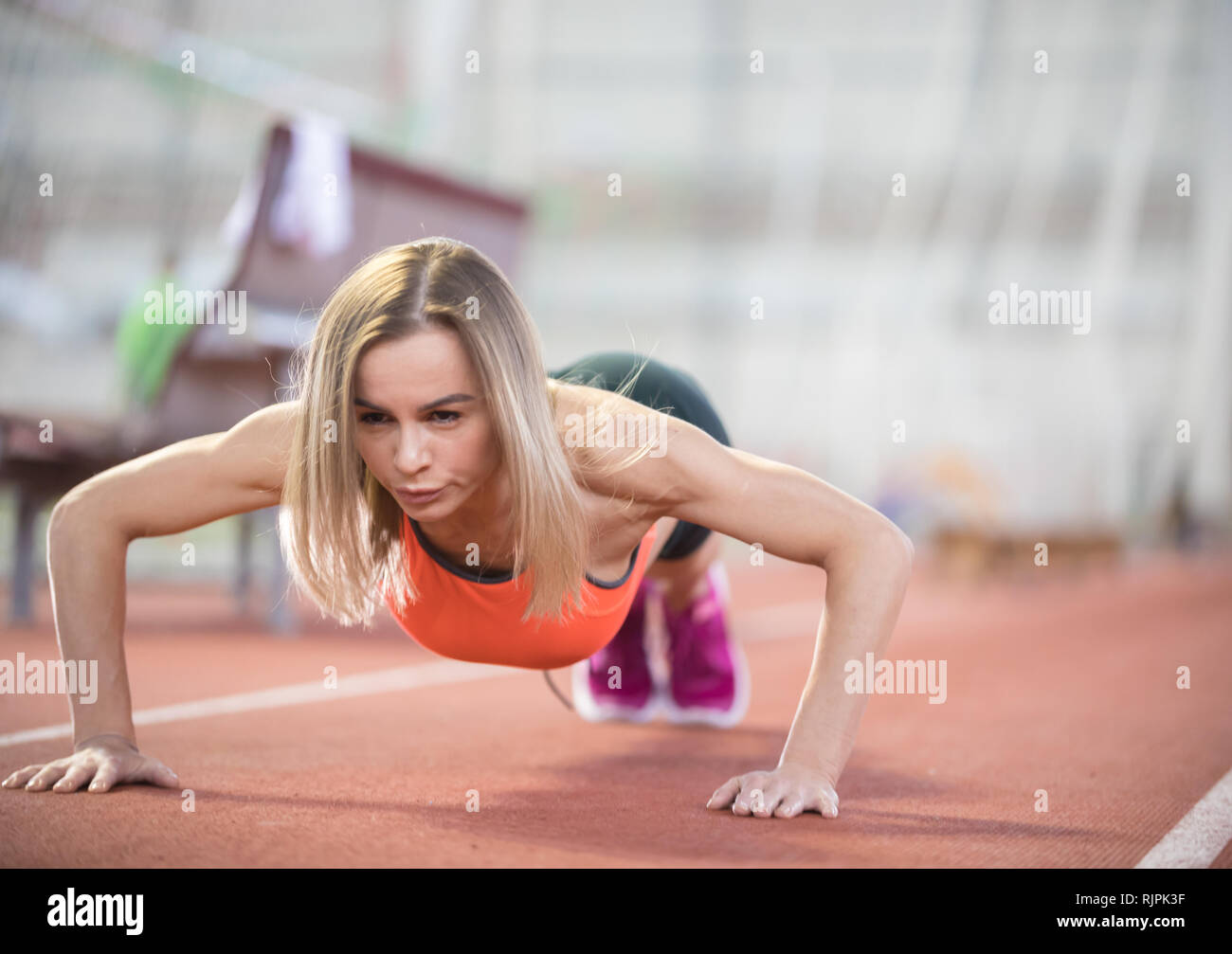 Young fit athletic woman doing push ups Stock Photo