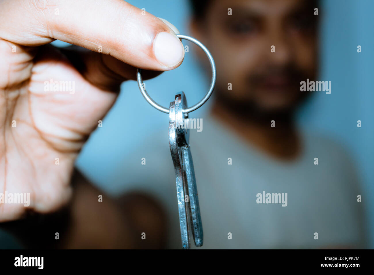 Business Men hand holding and showing a key ring. Real estate, moving in a new home or renting a property or Mortgage concept. Stock Photo