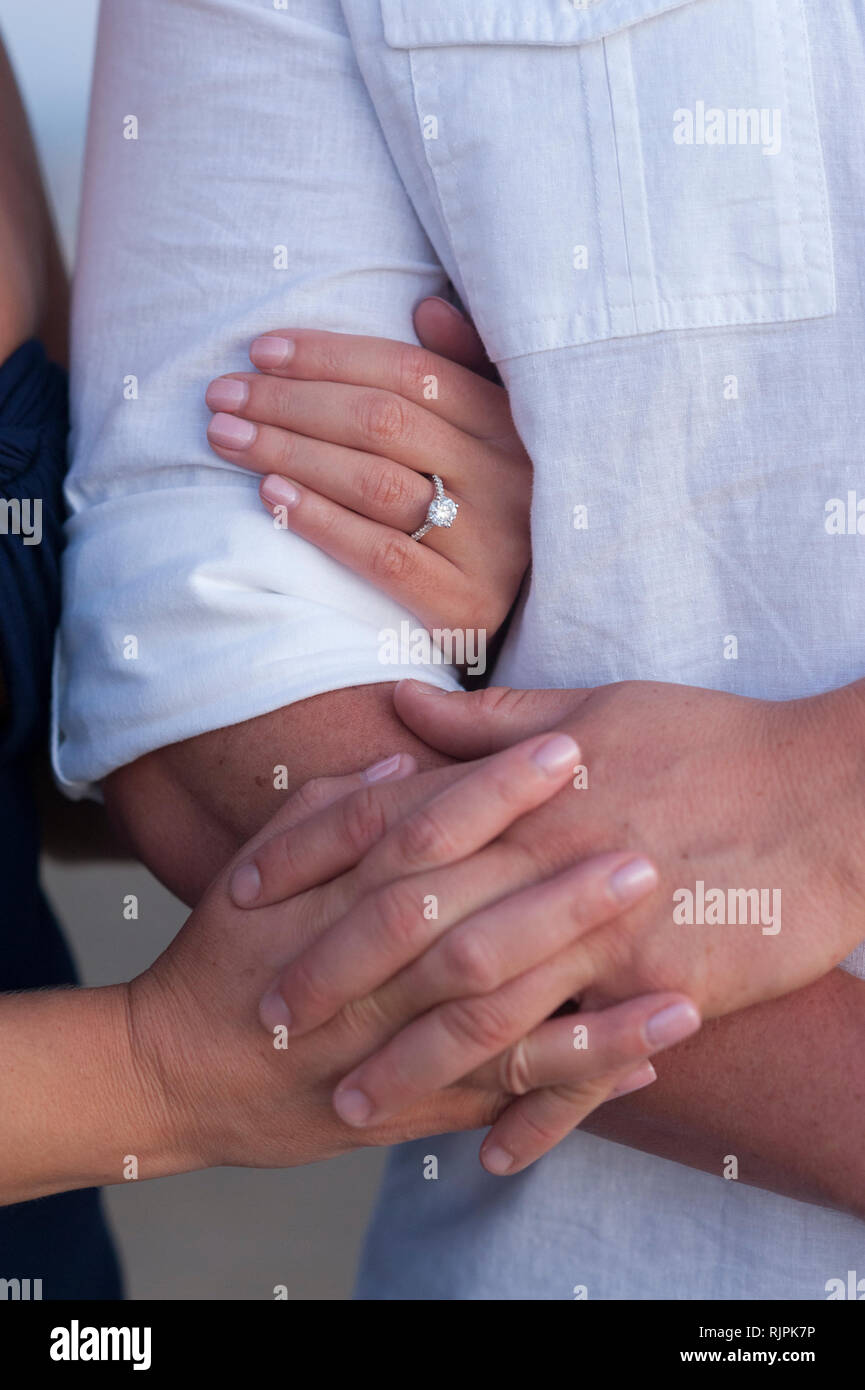 Close-up of an engaged couple holding each other's at the beach during an engagement photoshoot. Stock Photo