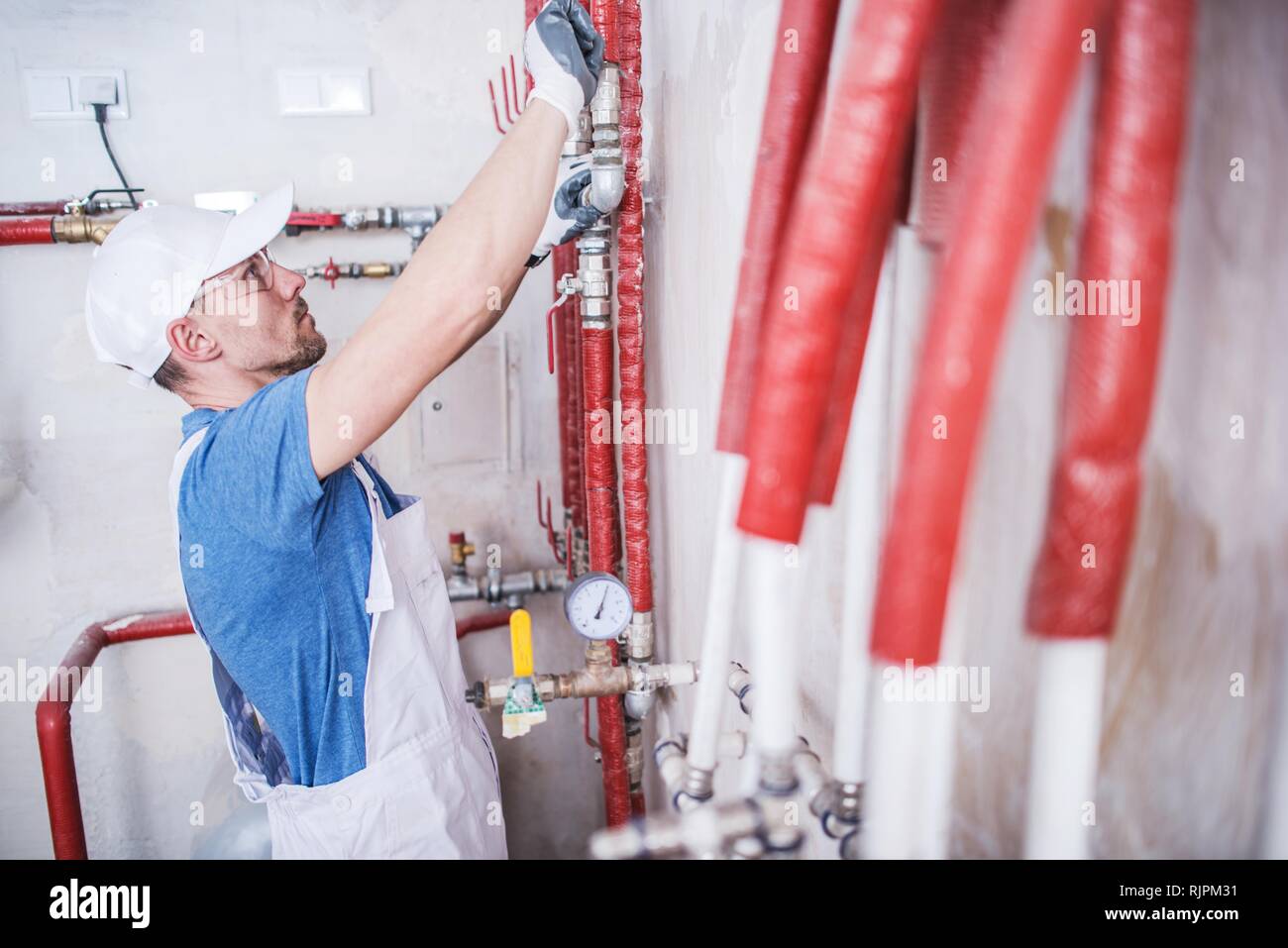 Hydraulic Heating Pipes and Caucasian Technician in His 30s Stock Photo