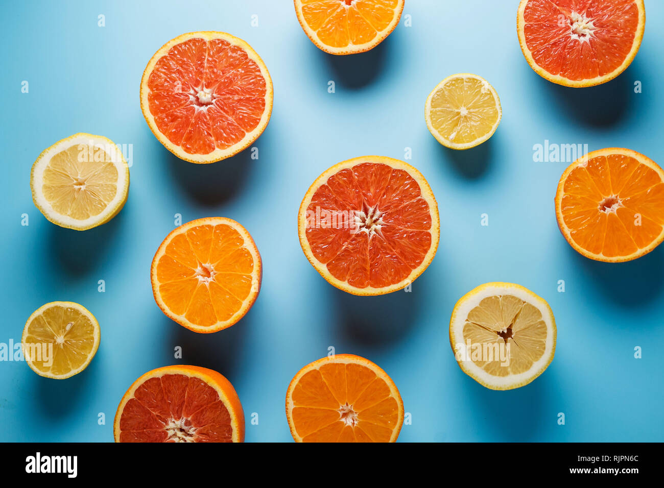 cut in half juicy citruses on a blue background, nice pattern Stock Photo