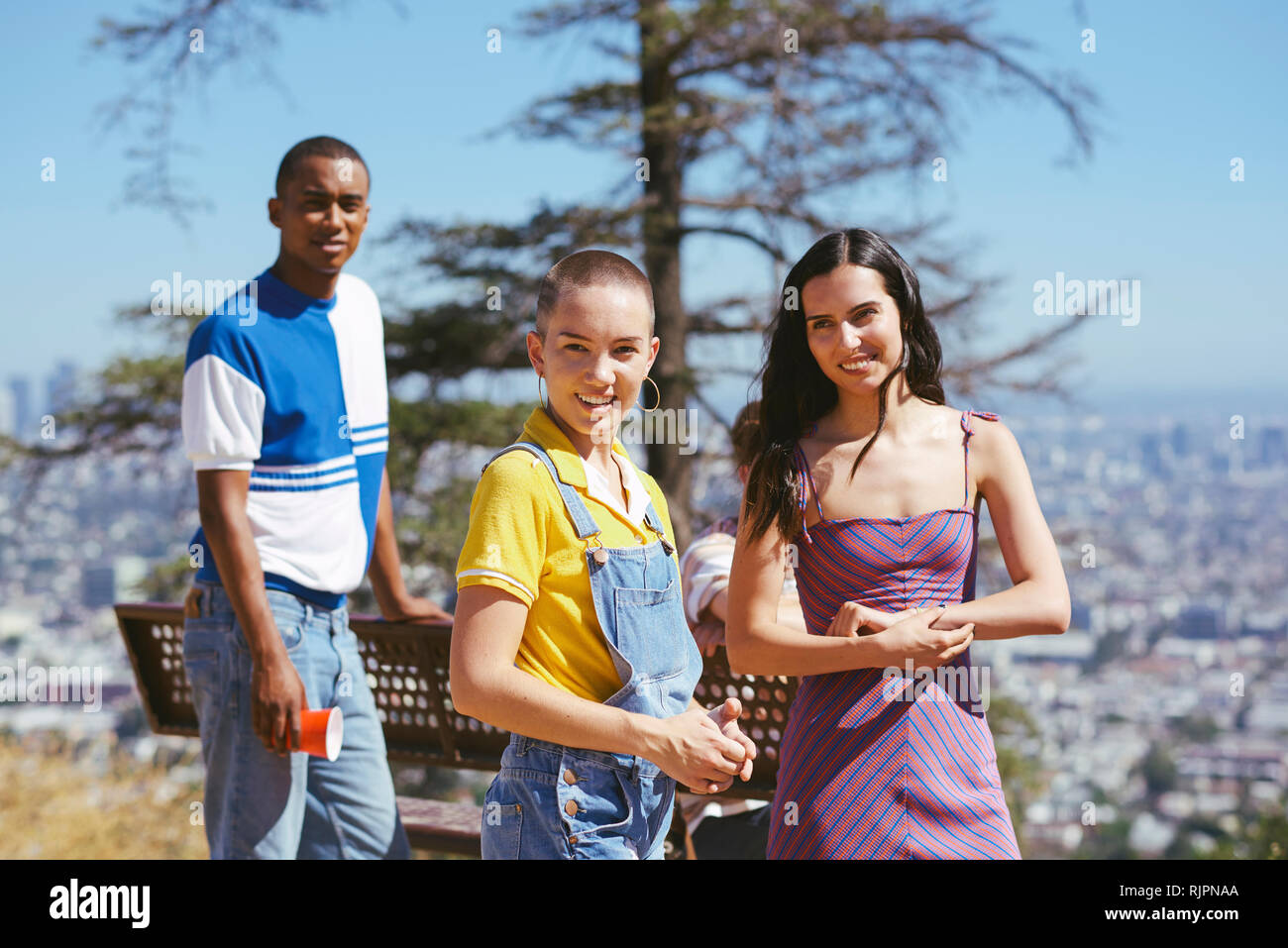 Three young adult friends on cityscape hilltop, Los Angeles, California, USA Stock Photo