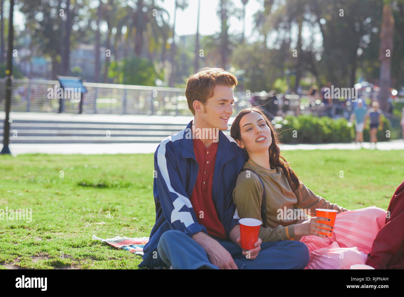 Young couple sitting in park, Los Angeles, California, USA Stock Photo