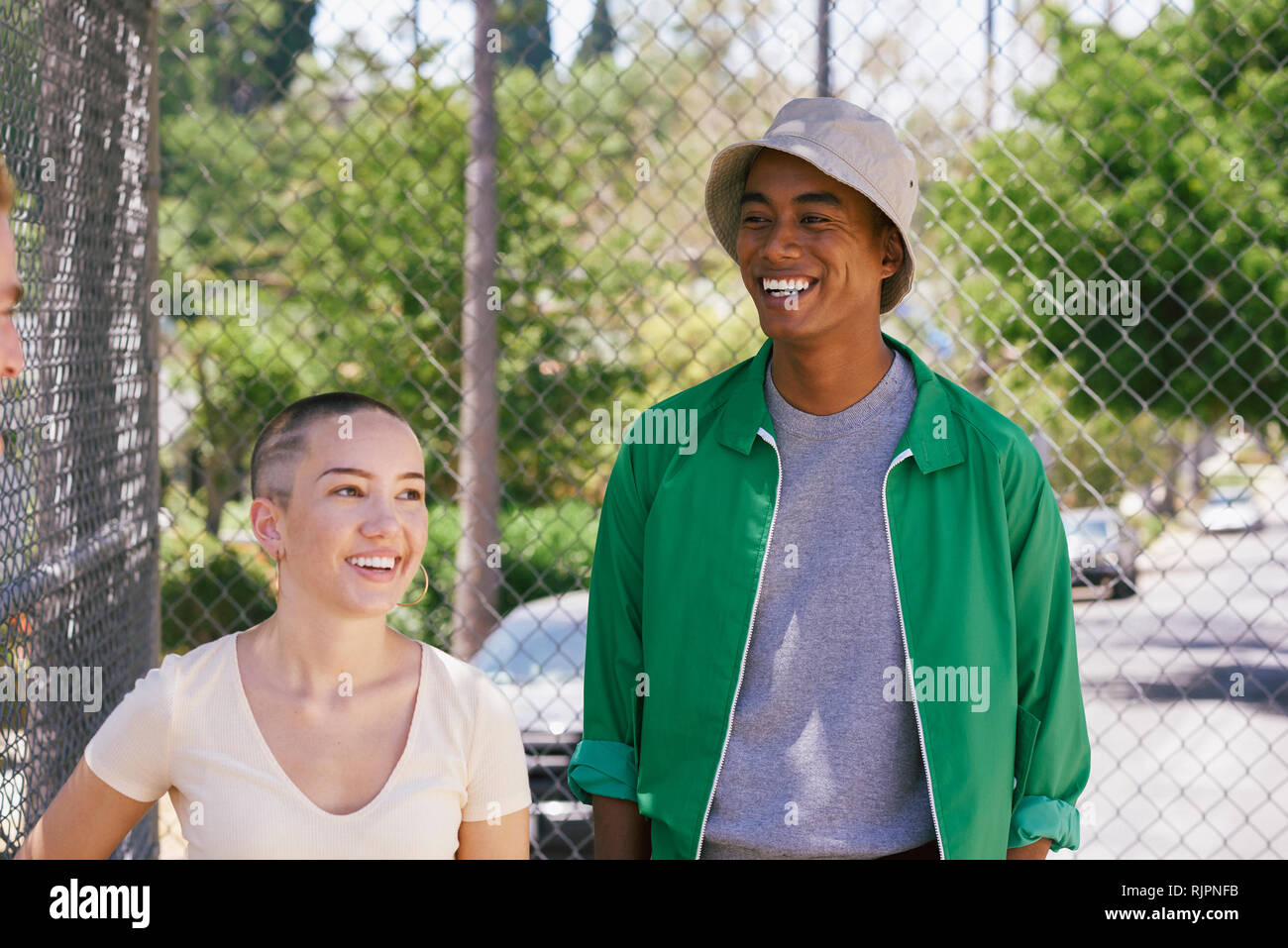 Young man and female friend by park fence, Los Angeles, California, USA Stock Photo