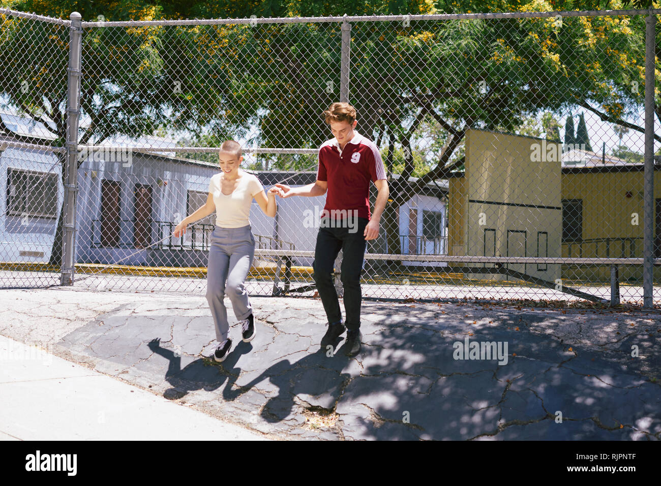 Young man giving female friend a helping hand in park, Los Angeles, California, USA Stock Photo