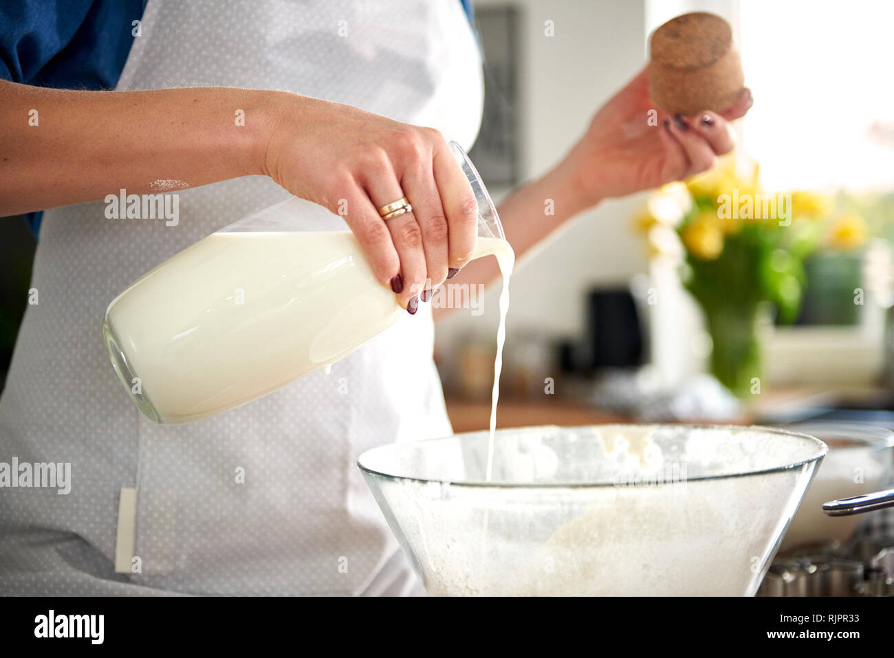 https://c8.alamy.com/comp/RJPR33/woman-pouring-milk-into-mixing-bowl-in-kitchen-RJPR33.jpg