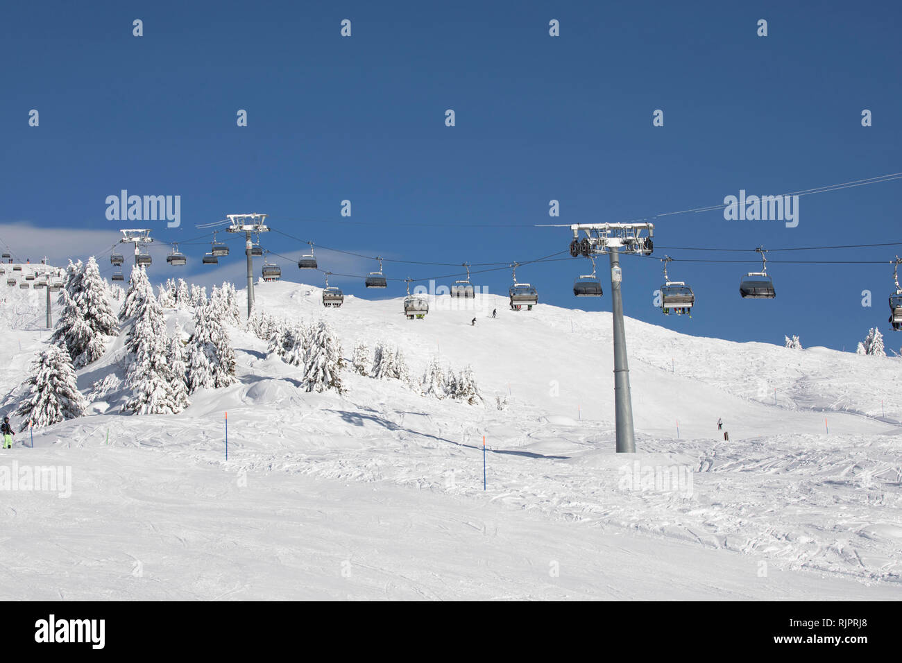 Ski resort, cable cars travelling above snowy slope, Zermatt, Valais, Switzerland Stock Photo