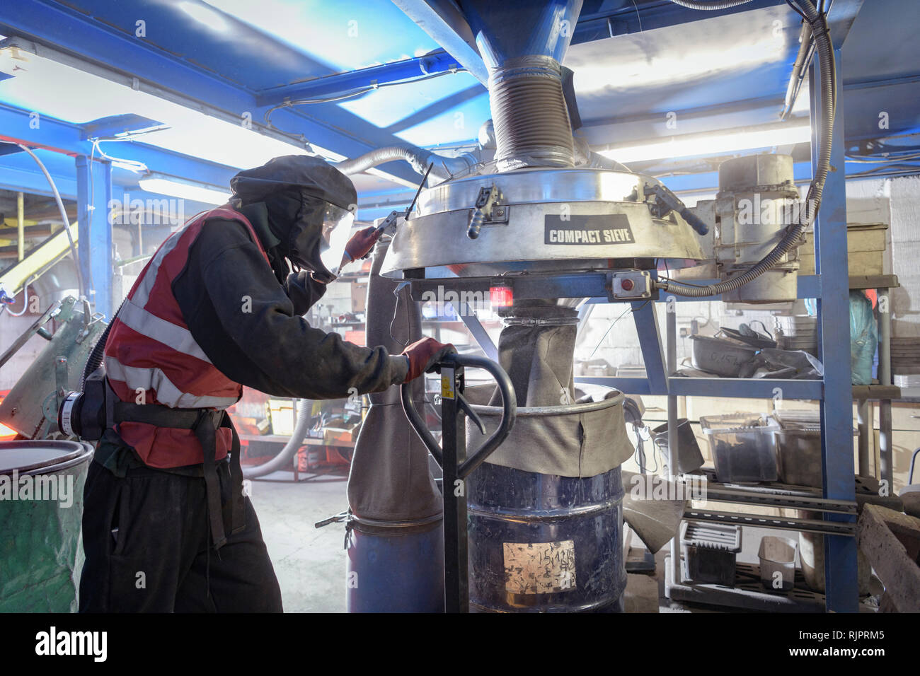 Worker sieving recycled metals from catalytic converters in recycling factory Stock Photo Alamy