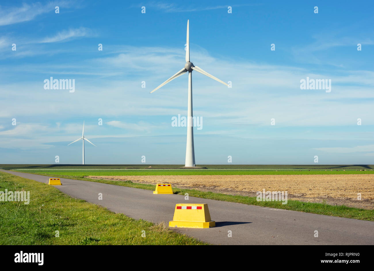 Road block near modern wind turbines on and offshore, Creil, Flevoland, Netherlands Stock Photo