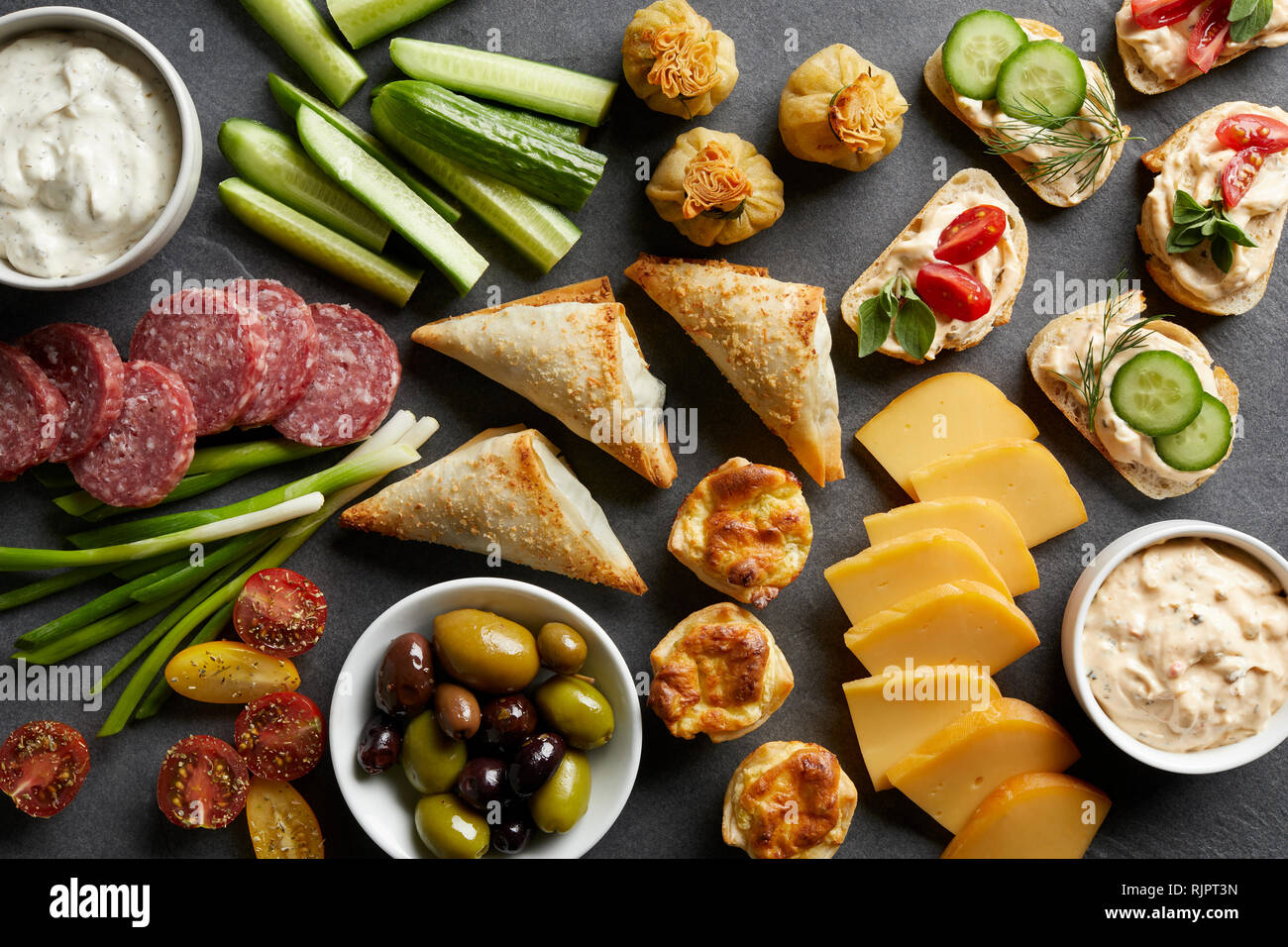 Appetiser snack spread with open sandwiches, olives and cheese , overhead view Stock Photo