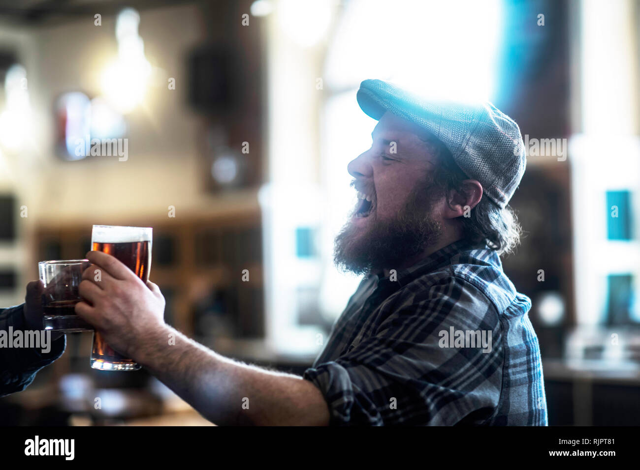 Two male customers making a toast in traditional Irish public house Stock Photo