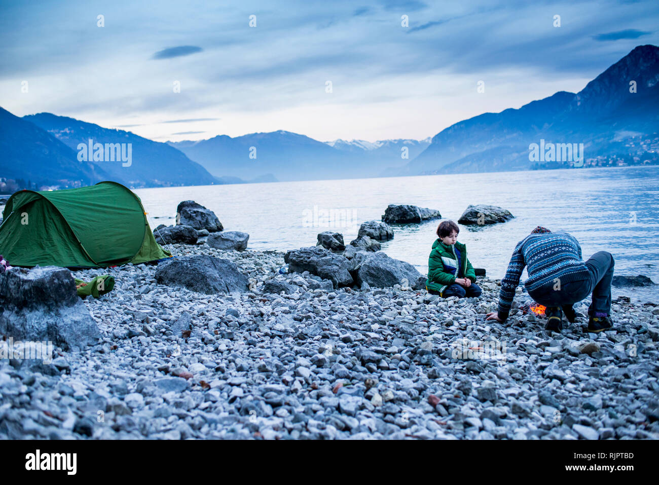 Father and son starting campfire, Onno, Lombardy, Italy Stock Photo