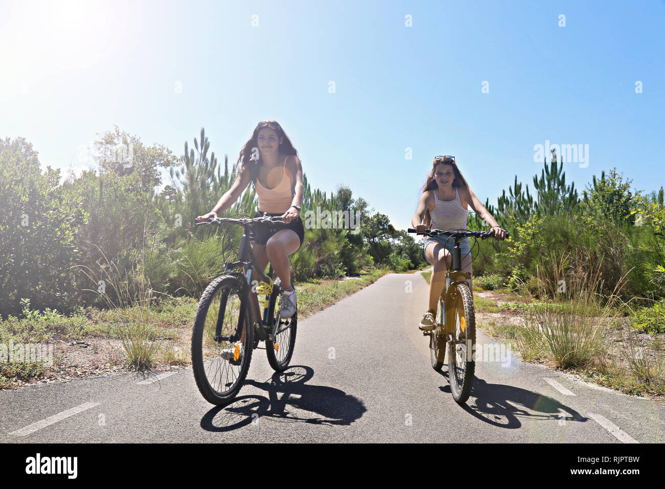 Teenagers cycling on countryside road, Aquitaine, France Stock Photo