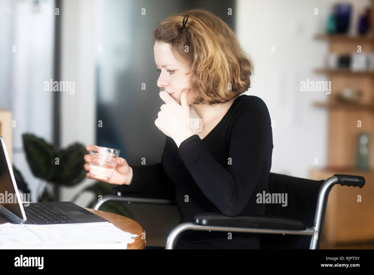 Woman in wheelchair working at laptop Stock Photo - Alamy