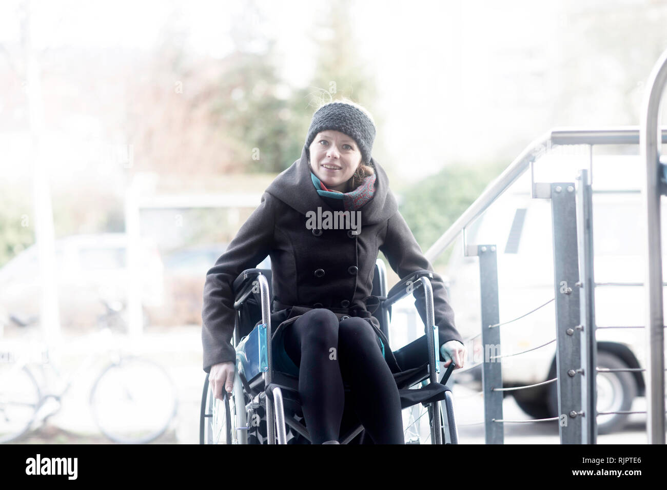 Woman in wheelchair moving up ramp Stock Photo