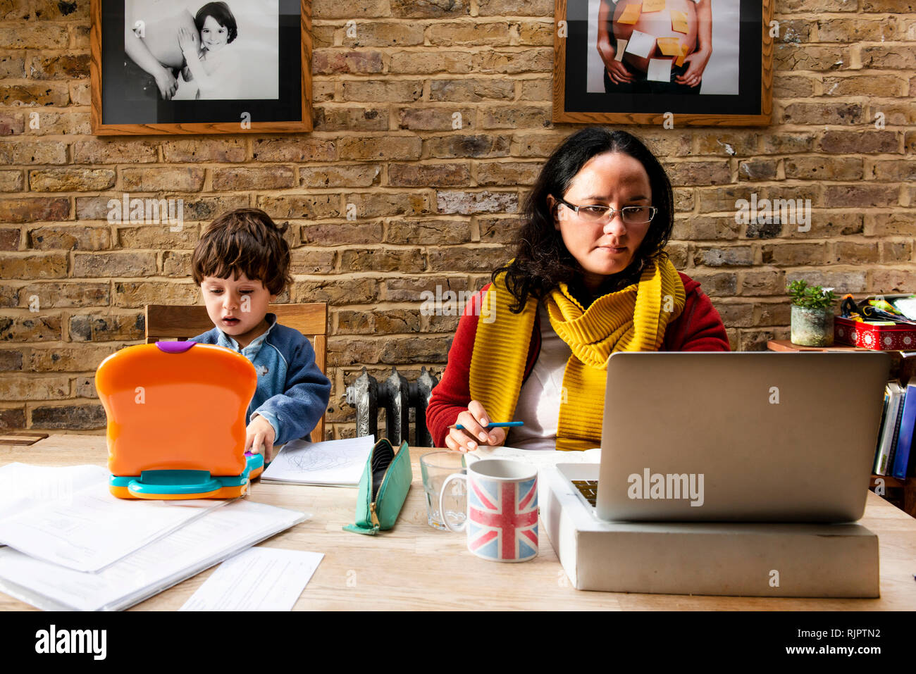 Toddler boy learning from mother working from home Stock Photo Alamy