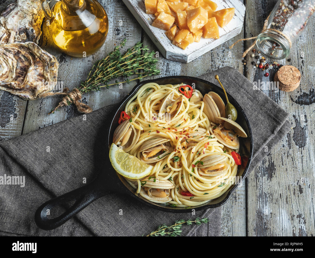 Pasta with seafood, shellfish clams in the iron pan portion, with lemon and seasoning Stock Photo