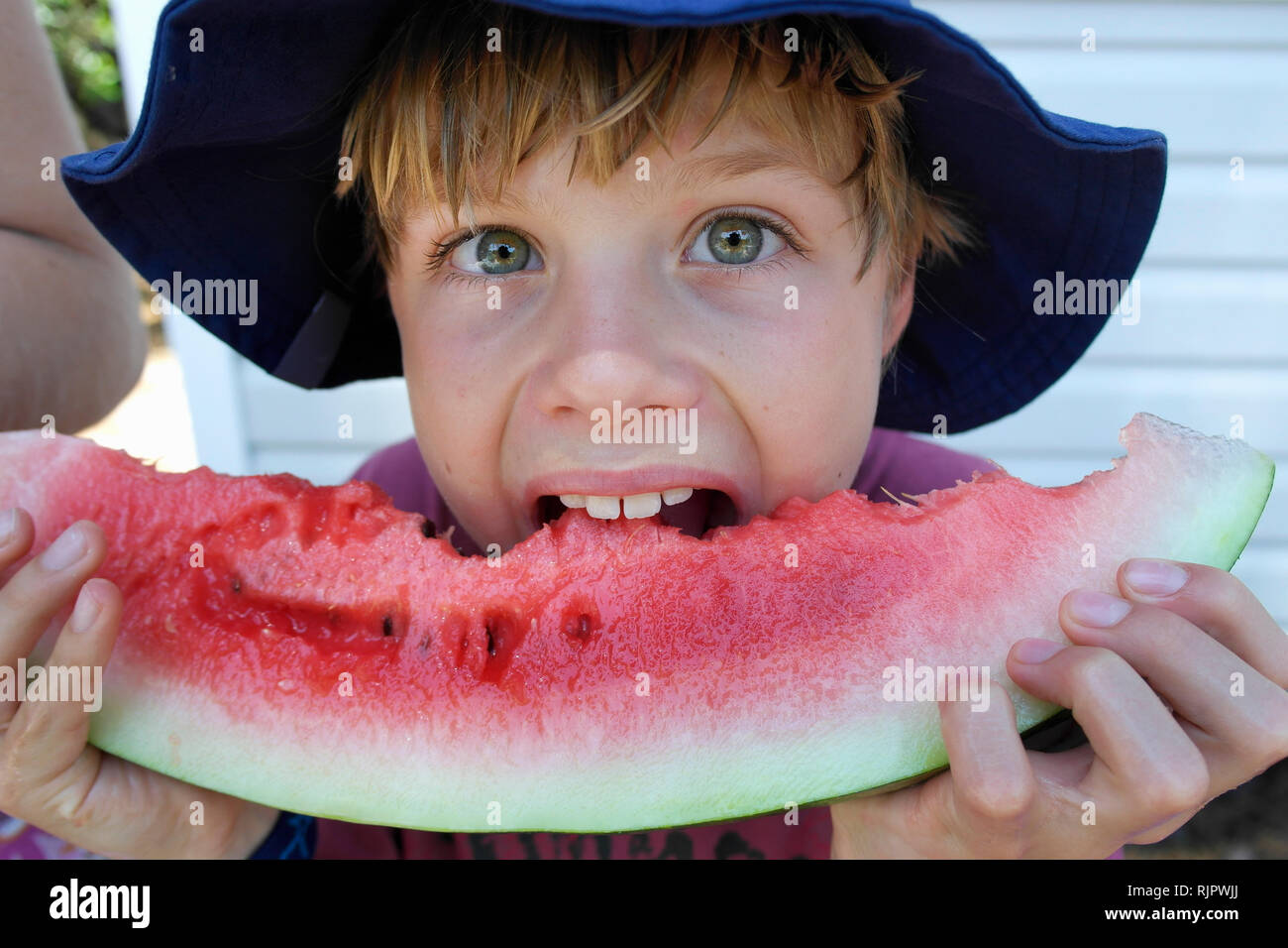 Boy biting into watermelon Stock Photo