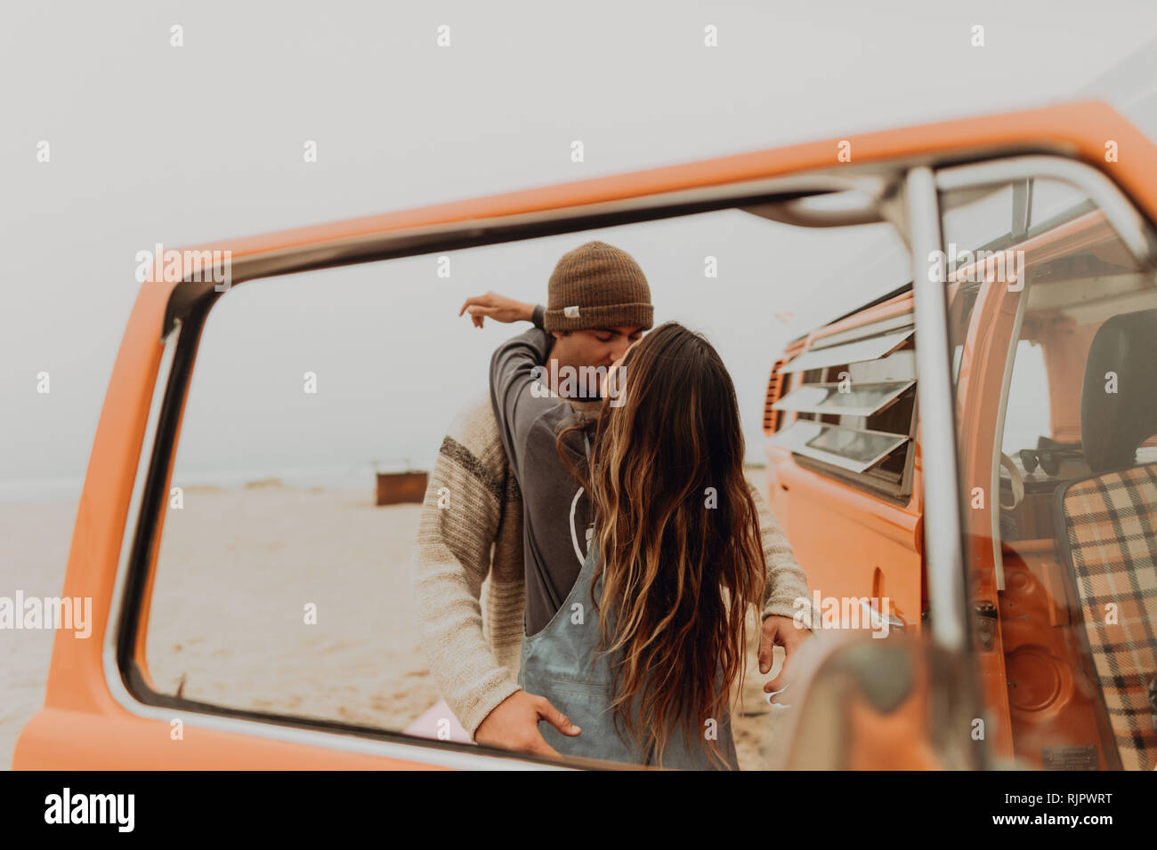 Young couple kissing by recreational vehicle at beach, Jalama, California, USA Stock Photo