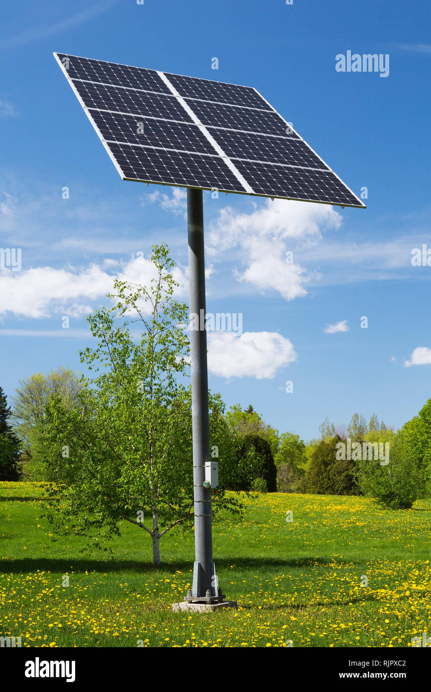 Solar energy collector panels mounted on metal post in field, Quebec
