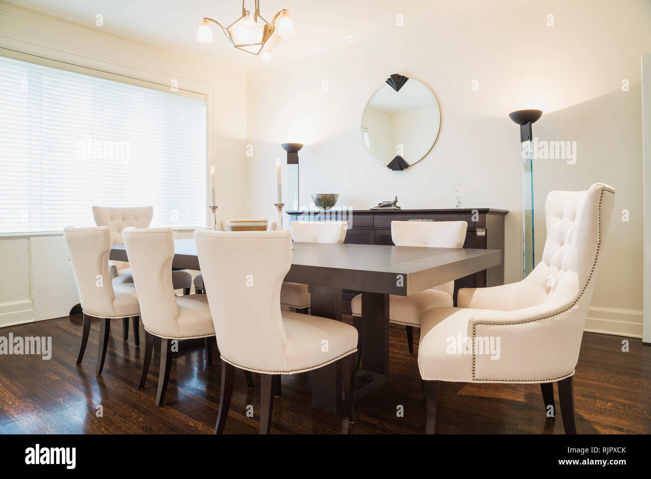 Dark Wood Dining Table With White Cloth Upholstered Chairs In