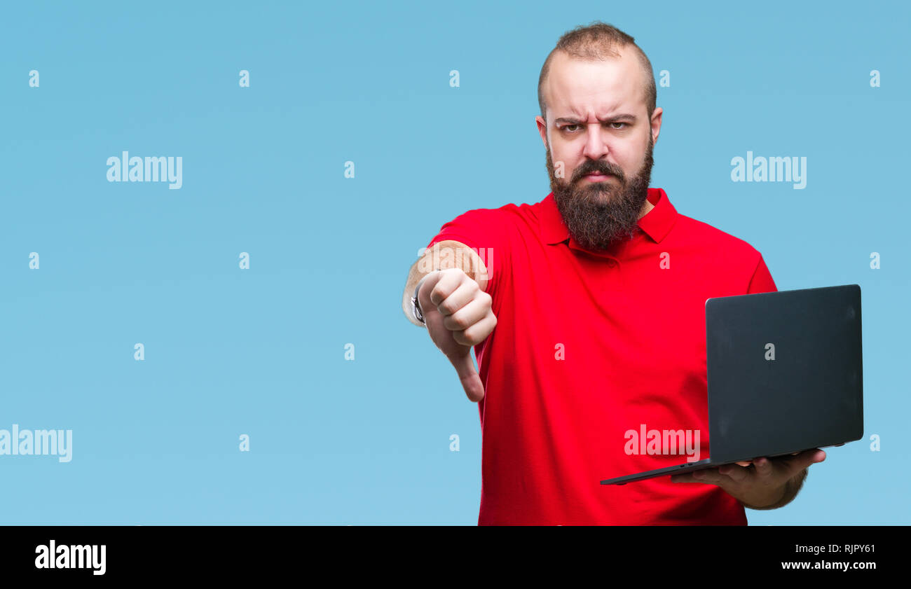 Young caucasian man using computer laptop over isolated background with ...