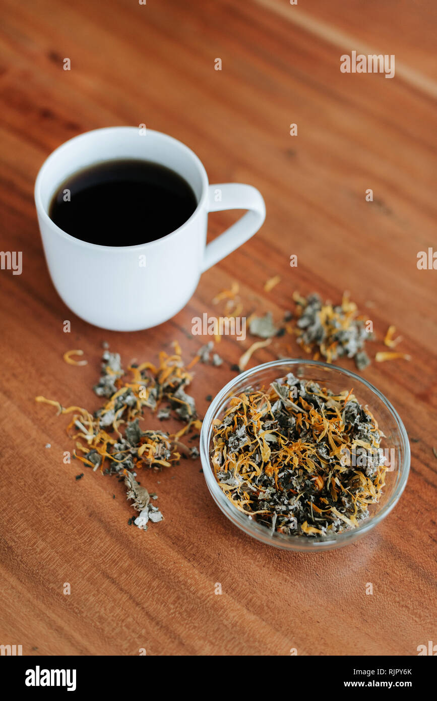 Mug of herbal tea and tea leaves Stock Photo