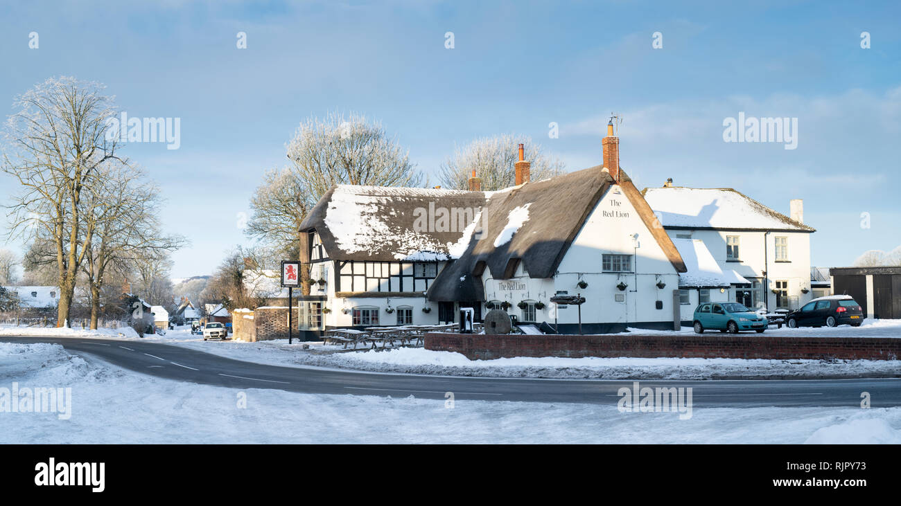 The red lion pub in the snow in Avebury, Wiltshire, England. Panoramic Stock Photo