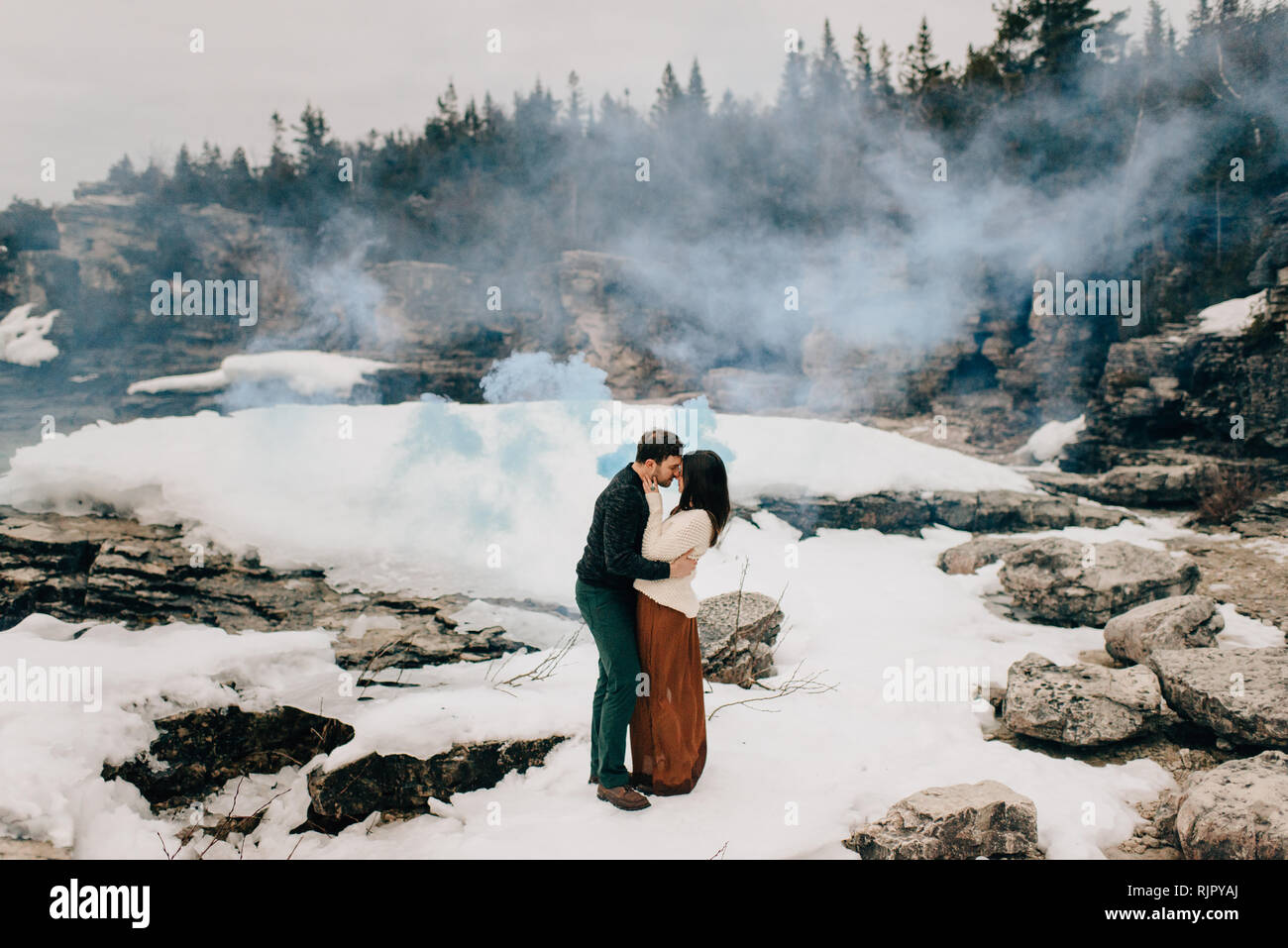 Couple kissing in snow and rock landscape, Tobermory, Canada Stock Photo
