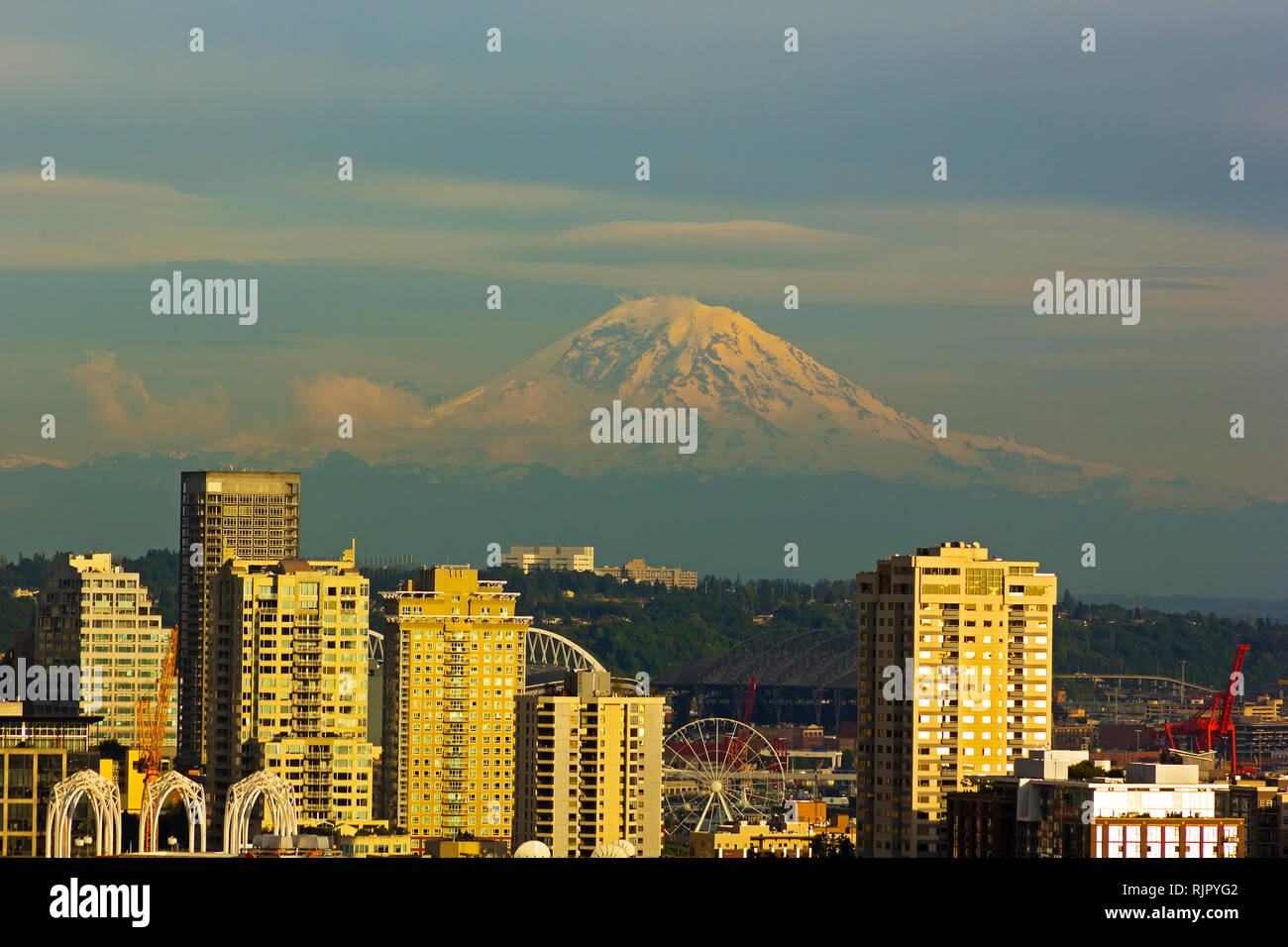 Mount Rainier and Seattle buildings at sunset hours. City view and